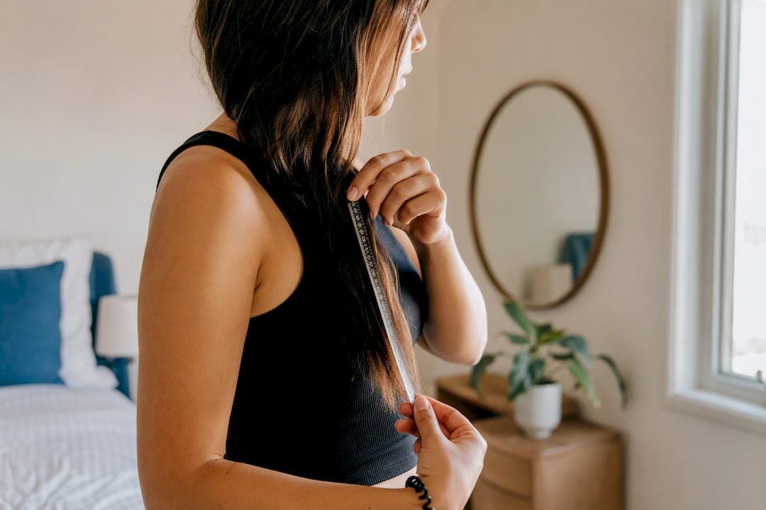 Hands measuring hair length with tape