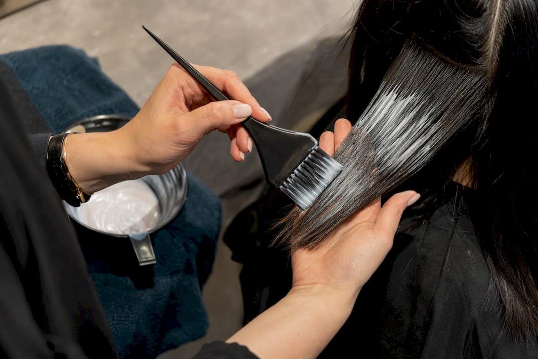 Colorist applying dye to hair section
